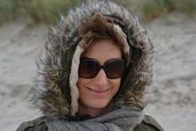 Smiling woman in dark sunglasses jacket