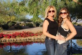 Happy mother and daughter near the lake