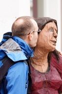 man kisses a wooden woman
