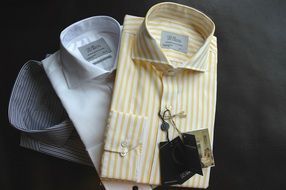 three men's shirts on a black background