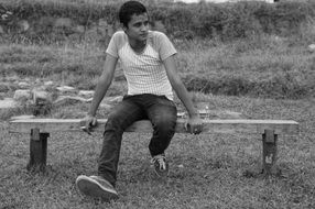 Black and white photo of the sitting man