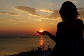 silhouette of woman sunset rays sea summer