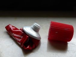 red empty toothpaste tube