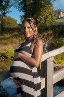 Pregnant black woman on nature background