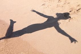 shadow silhouette of girl on sand