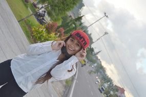 girl posing in a red cap on the street