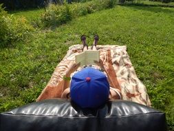 woman lies on a bedspread on green grass