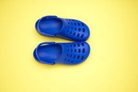 blue rubber sandals at yellow background