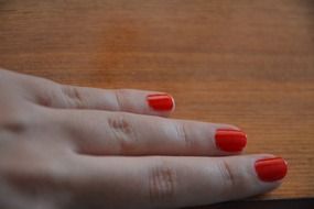 three young female fingers with red manicure