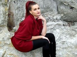 girl in red blouse on a background of stones