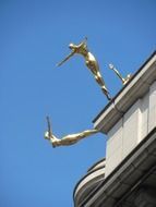 sculpture of a golden woman on the roof of a building