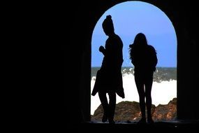 female silhouettes in the arched doorway