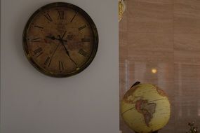 Old clock on wall and globe in interior