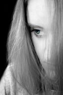 Black and white portrait of a sad woman at dark background