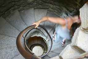 girl goes down a stone spiral staircase