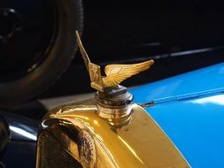 golden eagle on the hood of the shiny gold and blue retro car