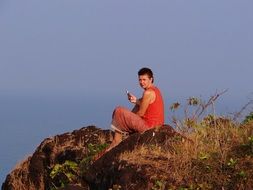 girl in red with a phone on the coast