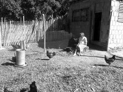 old woman in the yard economy black and white photo