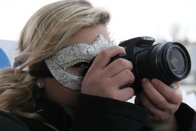 Woman with the mask is taking photos in Venice, Italy