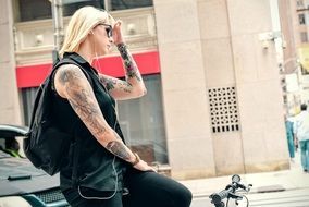 blonde with tattoos on the bike