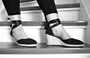 black and white photo of sandals on female legs
