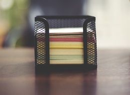 stack of colorful notes in a folder on an office desk