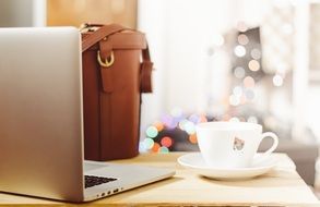 laptop and a cup of coffee on a wooden work desk