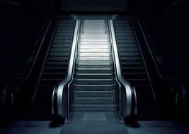 grey escalator surrounded by dim lights