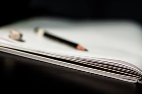 pencil and eraser lying on a notebook