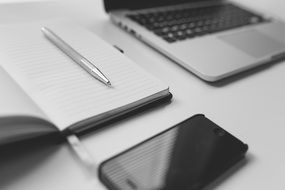 pen, notebook, laptop and smartphone on table, business still life