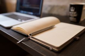 blank notebook with a pen on a desk