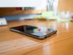 black iPhone 6s on a wooden office table