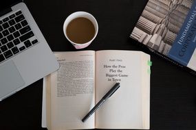 books coffee pen macbook on black table