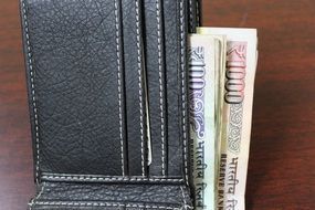 black wallet with indian bills