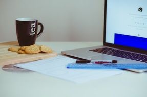 work space, desk with a computer and tea and biscuits