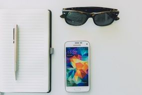 moleskin and smartphone on white background