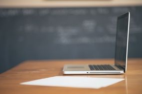 opened laptop paper leaf on wooden table