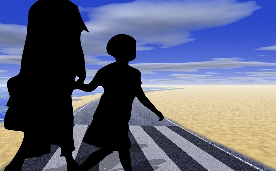 silhouette of a woman with a child at a crosswalk