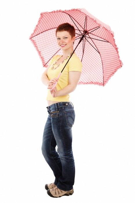 girl in jeans posing with a pink umbrella