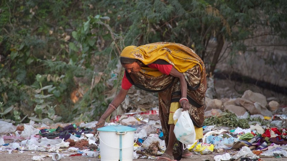 Indian woman looking in the garbage