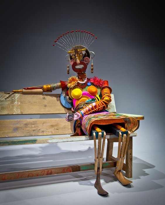 afro figure of modern art on a bench