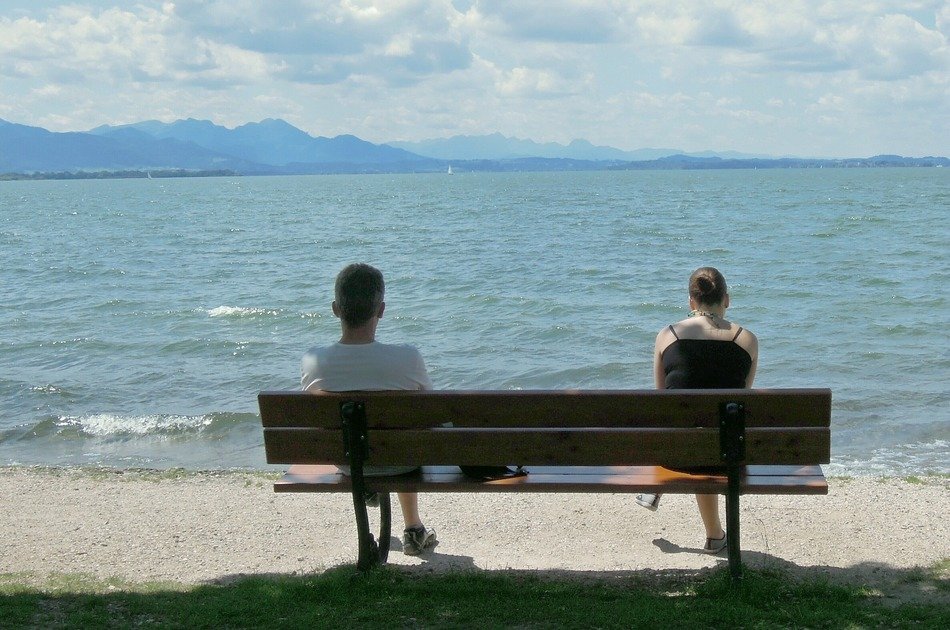 two on a bench near the lake