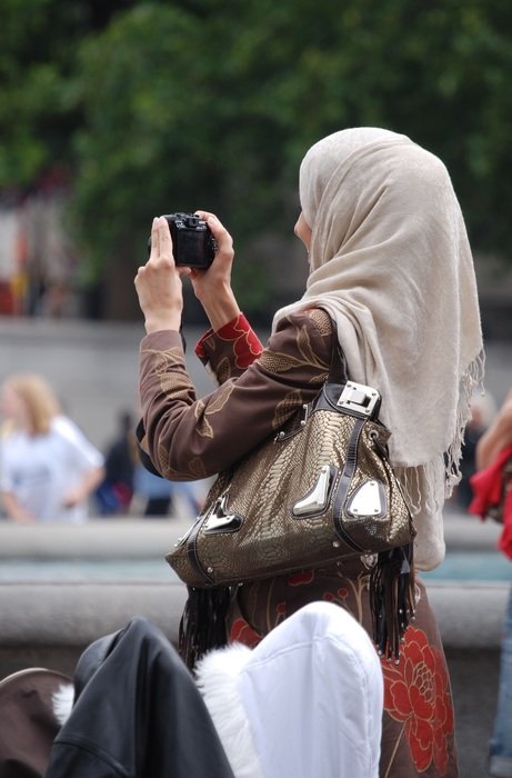 sightseer with a camera in hand taking pictures of London landmarks