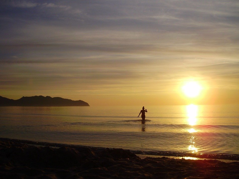 woman swimming at sunset