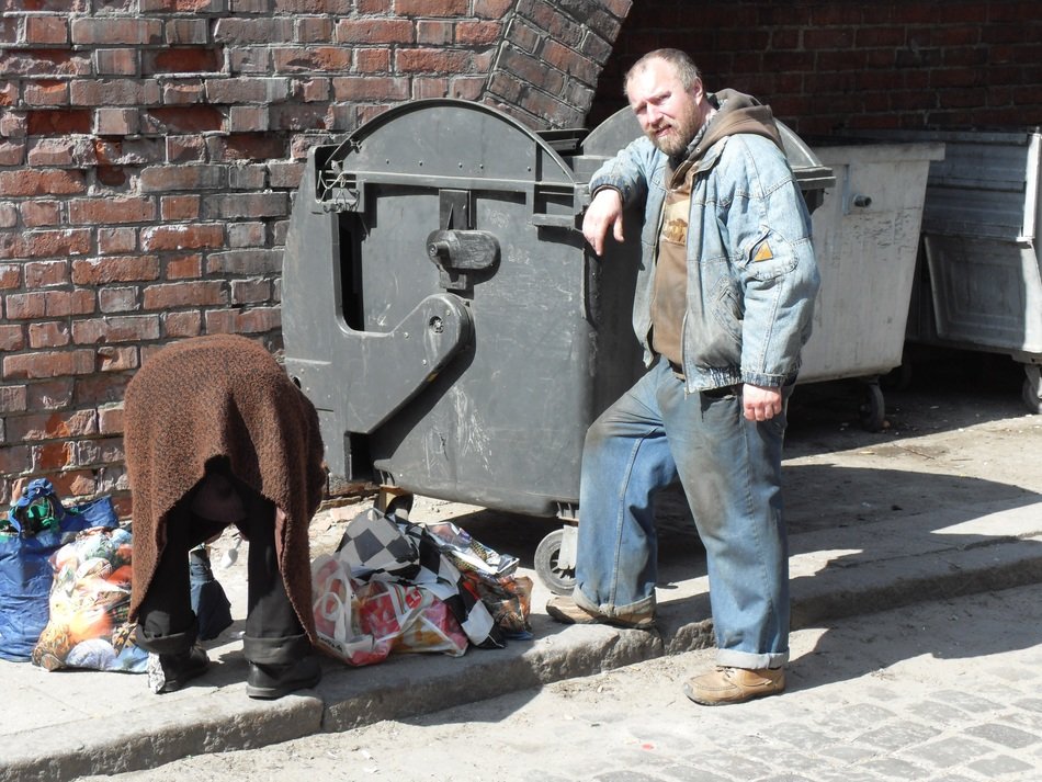 homeless couple near a garbage container in poland