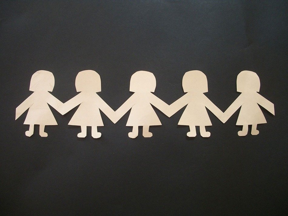 paper dolls on a black table