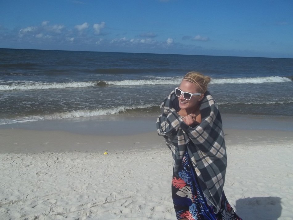 woman wrap up in plaid on beach at sea, poland