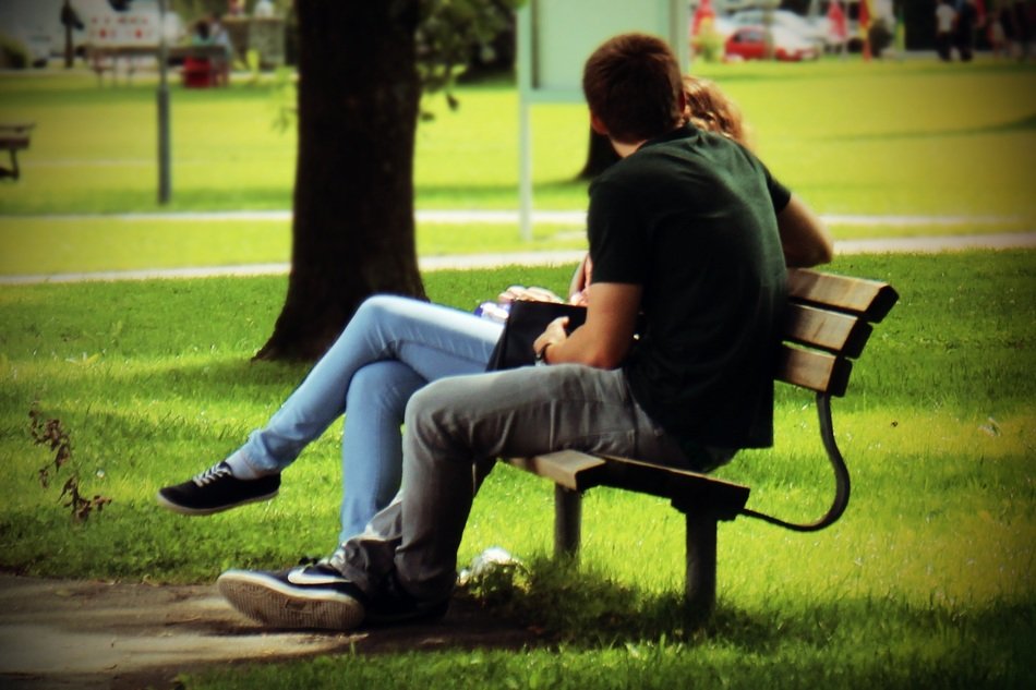 couple in love on a bench in a green park