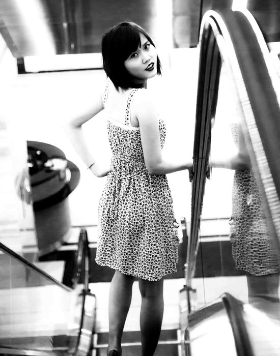 cute asian girl in dress on escalator