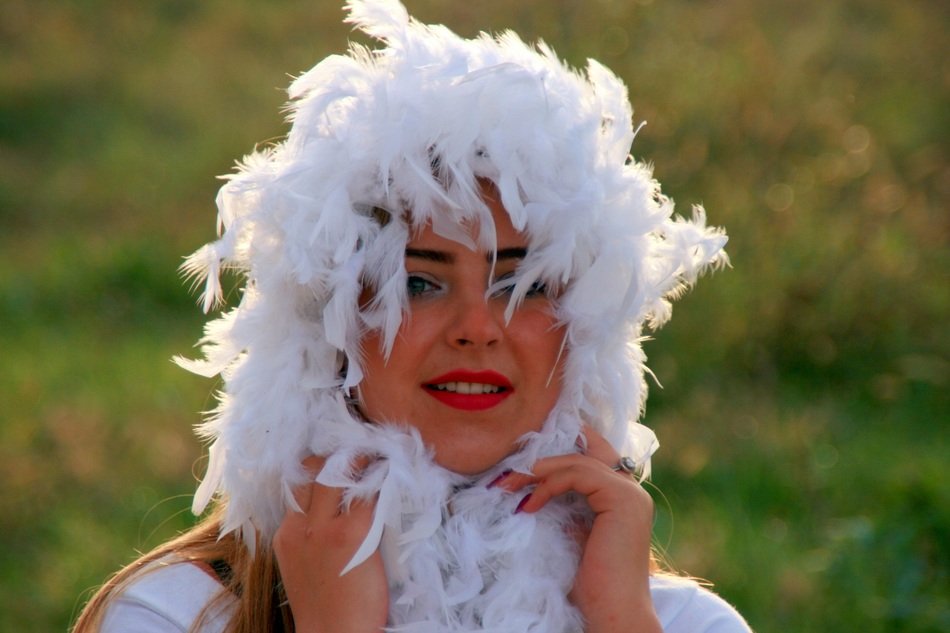 girl with bright lips in white feathers